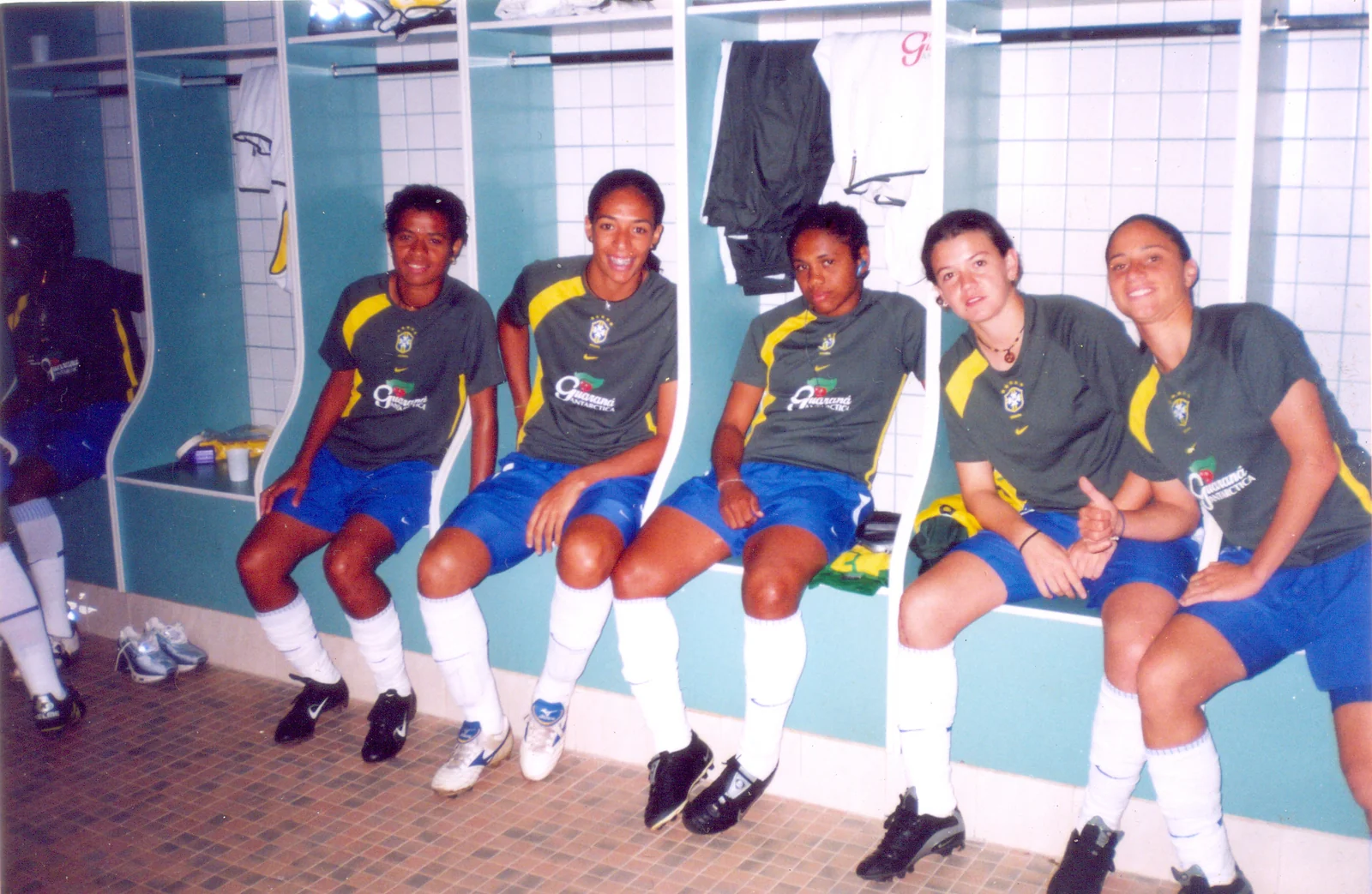 Brazil women’s national-team players in a locker room, wearing Brazil training shirts.