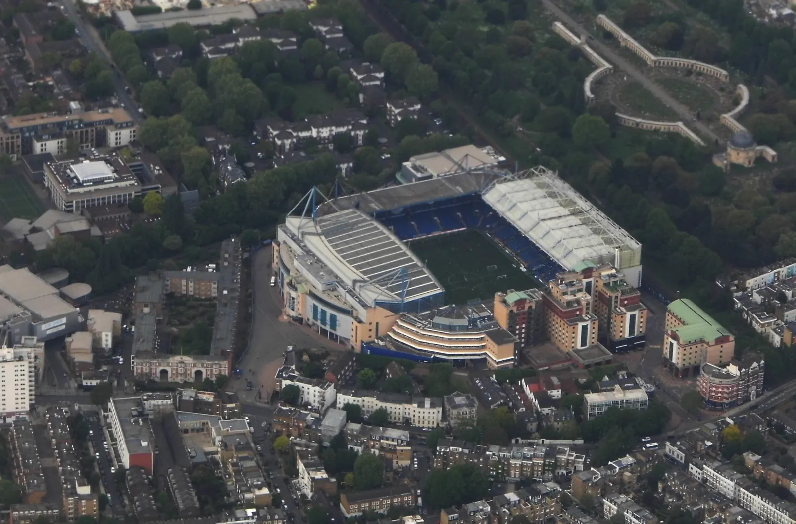 An aerial view of Stamford Bridge among surrounding streets and buildings.