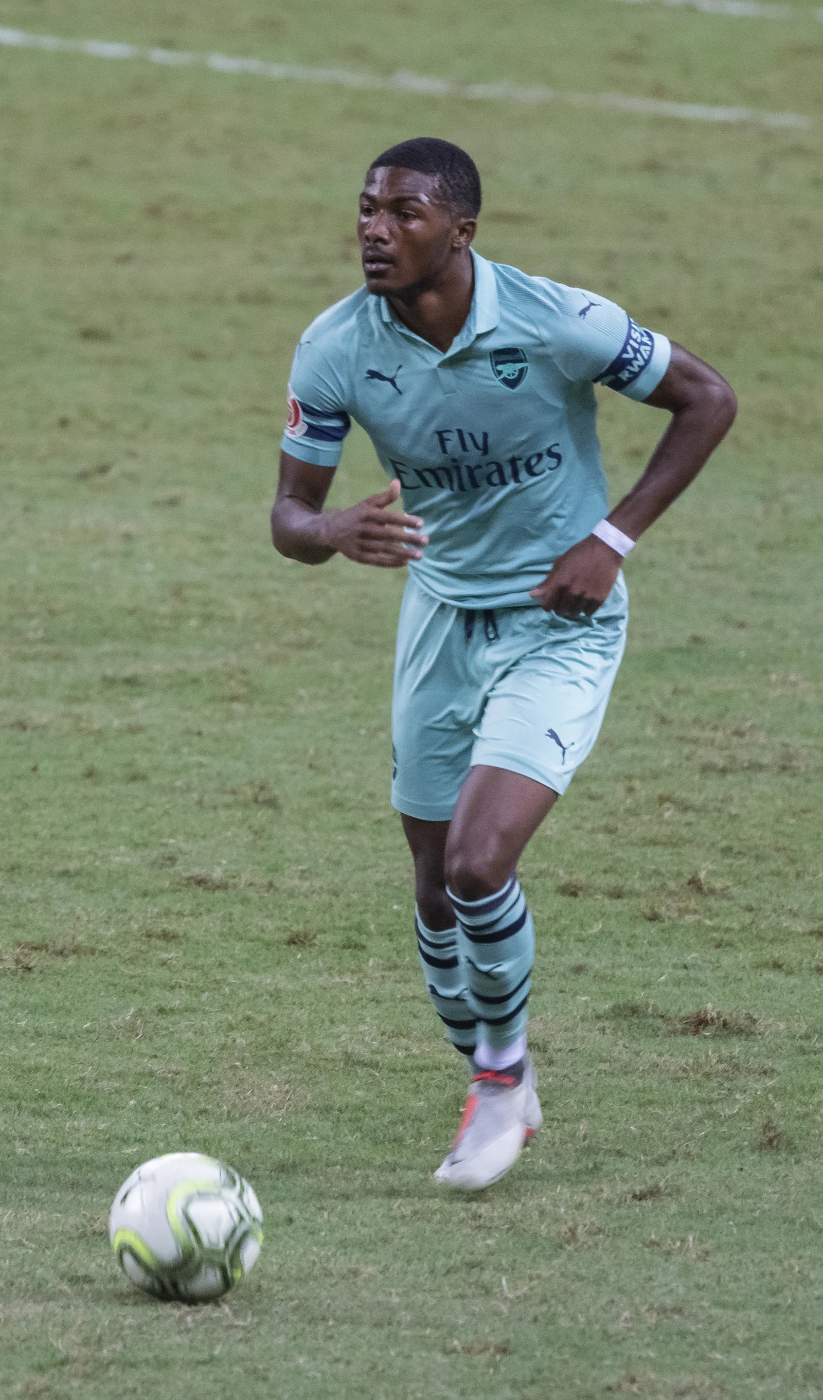 Ainsley Maitland-Niles in an Arsenal kit approaching the ball in July 2018.