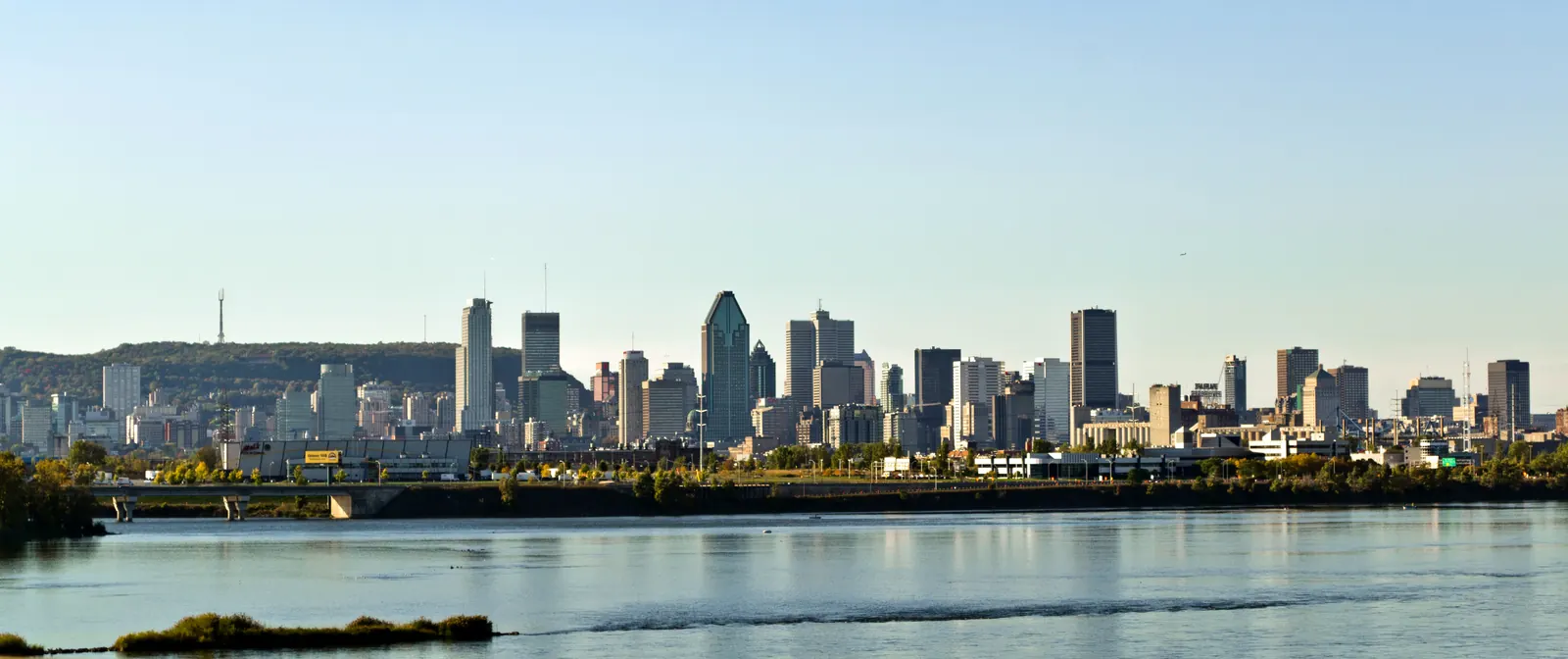 Montréal’s skyline across the Saint Lawrence River in evening light.