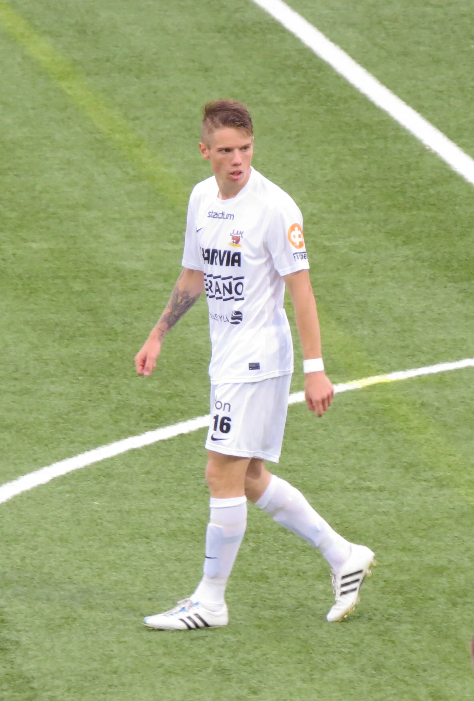 Robert Taylor wearing a white football kit on a grass pitch.
